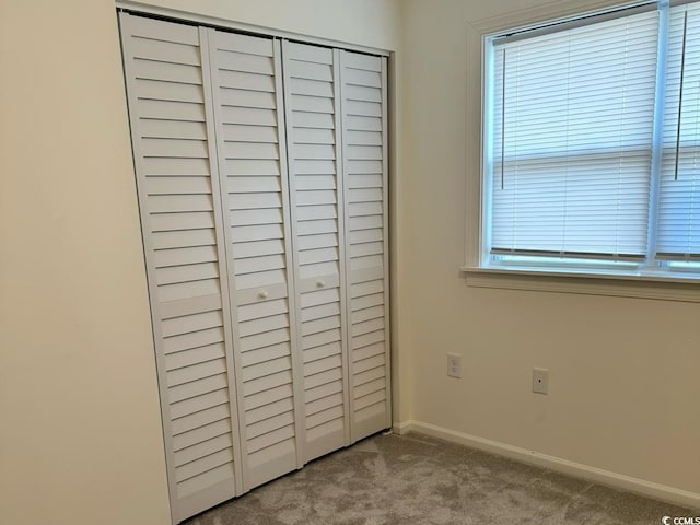 unfurnished bedroom featuring a closet, baseboards, and carpet flooring