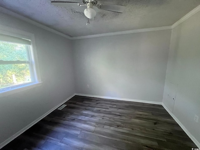 spare room featuring a textured ceiling, ornamental molding, dark wood-style flooring, and baseboards