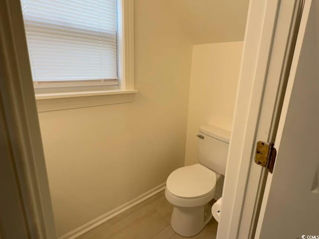 bathroom with baseboards and toilet