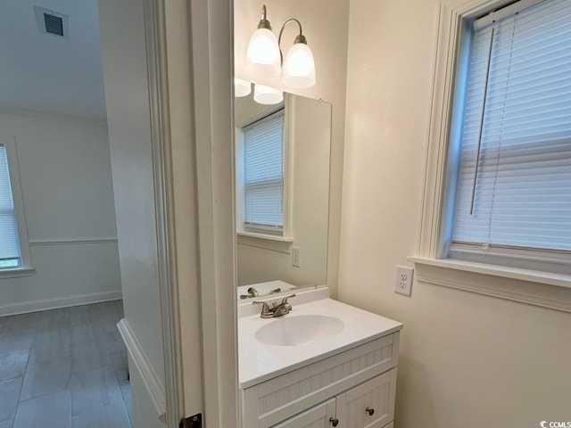 bathroom featuring visible vents, vanity, and baseboards