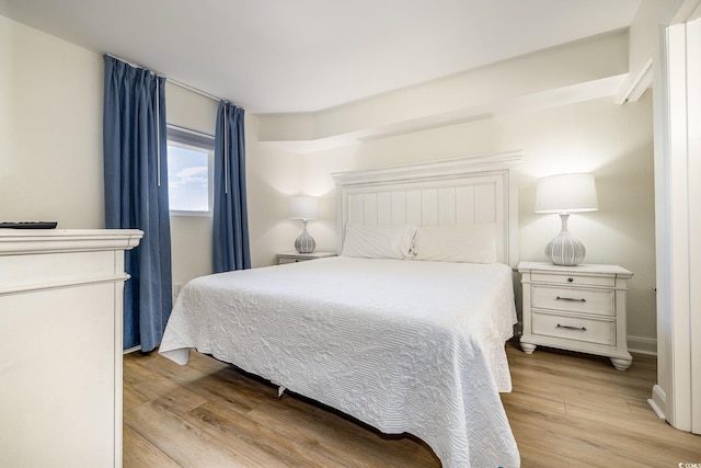 bedroom with light wood-style flooring and baseboards