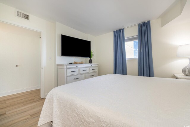 bedroom featuring baseboards, visible vents, and light wood-type flooring