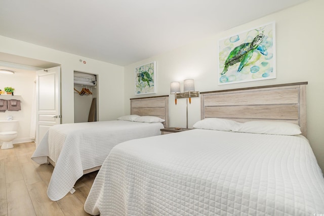 bedroom with wood finished floors and ensuite bath