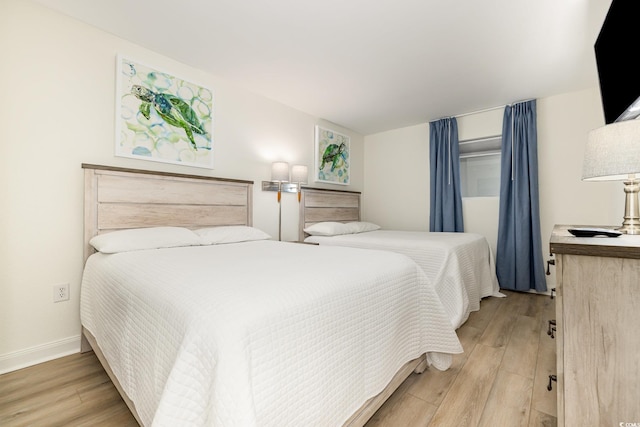 bedroom with light wood-style floors and baseboards