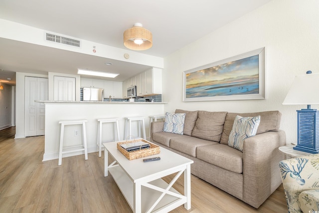 living area featuring visible vents and light wood-type flooring