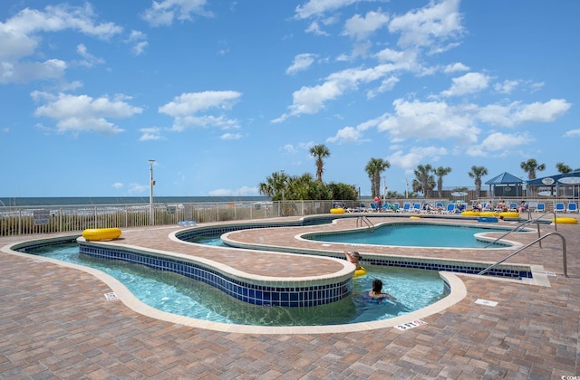 community pool featuring fence, a patio, and a jacuzzi