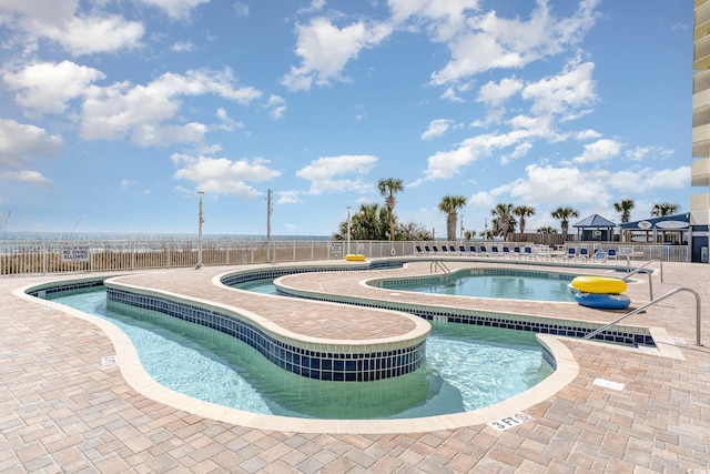 community pool with fence and a patio area