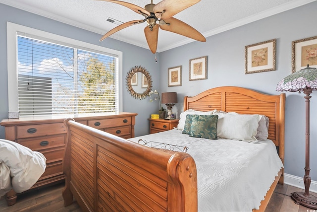 bedroom featuring dark wood finished floors, visible vents, a textured ceiling, and crown molding