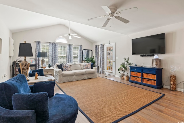 living area featuring vaulted ceiling, ceiling fan, light wood finished floors, and baseboards