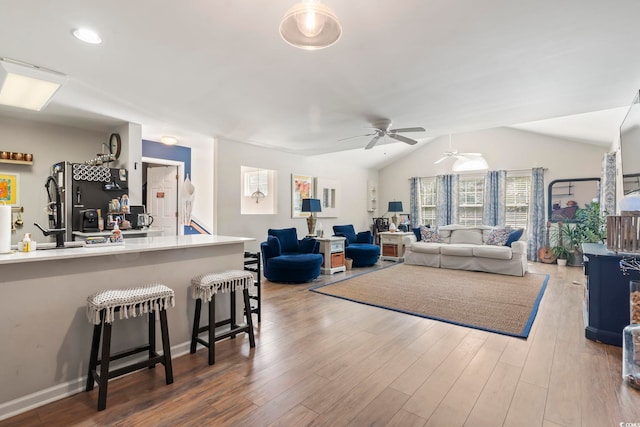 living area featuring vaulted ceiling and wood finished floors