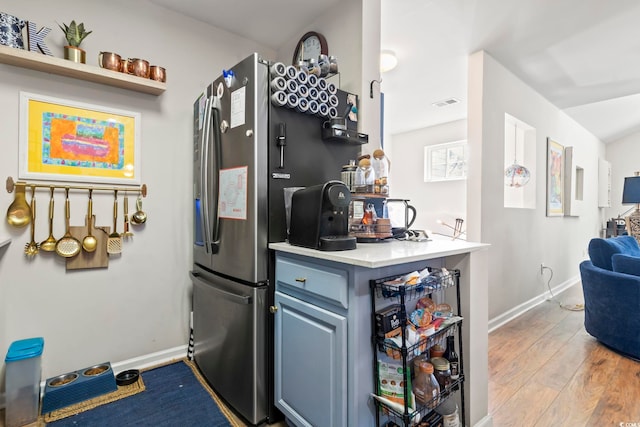 kitchen with visible vents, light countertops, light wood-style flooring, and baseboards