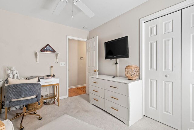 office area featuring light carpet, baseboards, and a ceiling fan