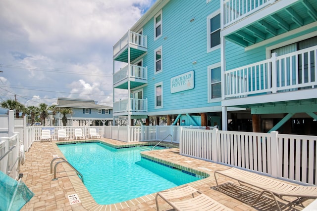 pool with a patio area and fence