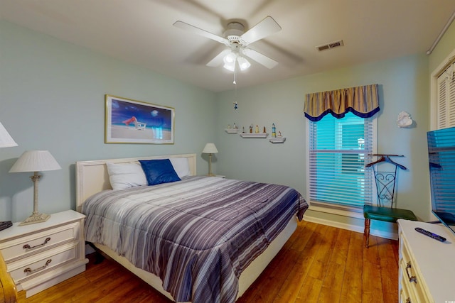 bedroom with hardwood / wood-style flooring, ceiling fan, and visible vents