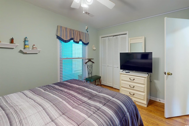 bedroom featuring a closet, visible vents, light wood-style floors, ceiling fan, and baseboards