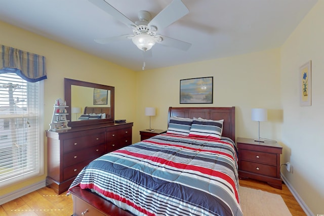 bedroom with light wood-style floors, baseboards, and a ceiling fan