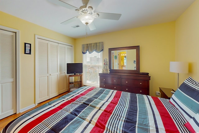 bedroom featuring baseboards, visible vents, a ceiling fan, and wood finished floors