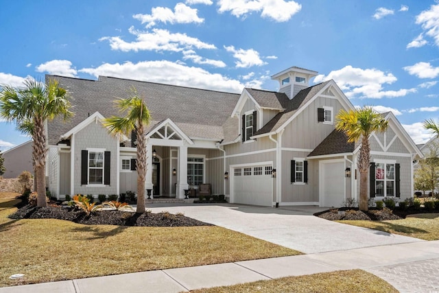 view of front of home with an attached garage, a shingled roof, driveway, board and batten siding, and a front yard