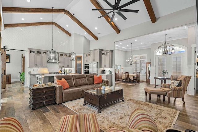 living room with high vaulted ceiling, ceiling fan with notable chandelier, hardwood / wood-style floors, and beam ceiling