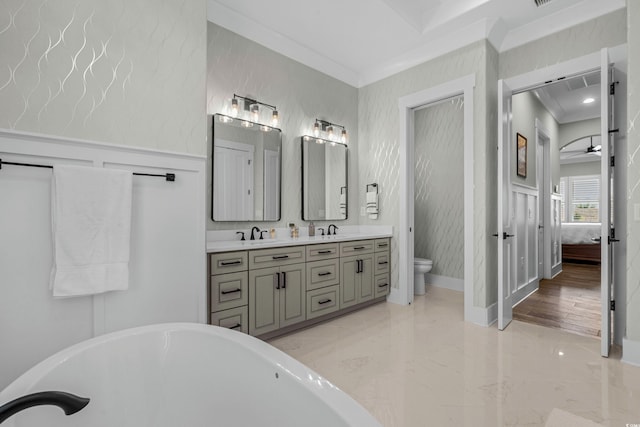 bathroom with crown molding, a soaking tub, toilet, marble finish floor, and a sink
