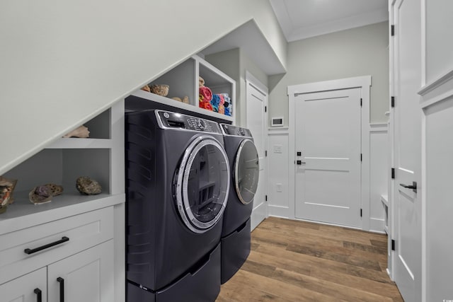 laundry area with laundry area, crown molding, washing machine and dryer, and light wood-style floors