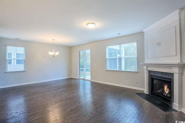 unfurnished living room with a wealth of natural light, baseboards, dark wood finished floors, and a fireplace