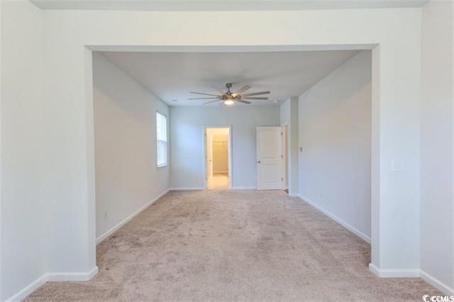 spare room with baseboards, carpet, and a ceiling fan