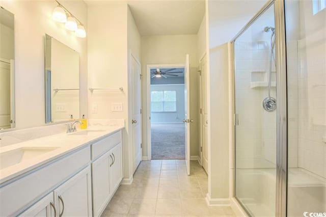 bathroom featuring tile patterned floors, a shower stall, double vanity, and a sink