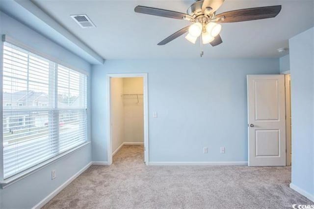 unfurnished bedroom featuring visible vents, a closet, carpet, baseboards, and a spacious closet