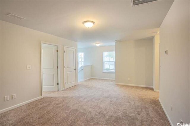 empty room with visible vents, baseboards, and carpet flooring