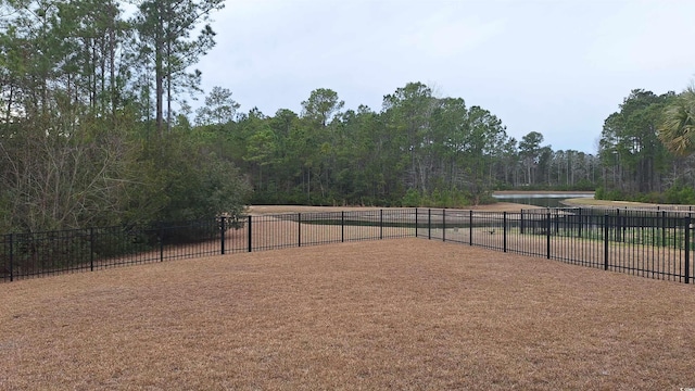 view of property's community with a view of trees and fence