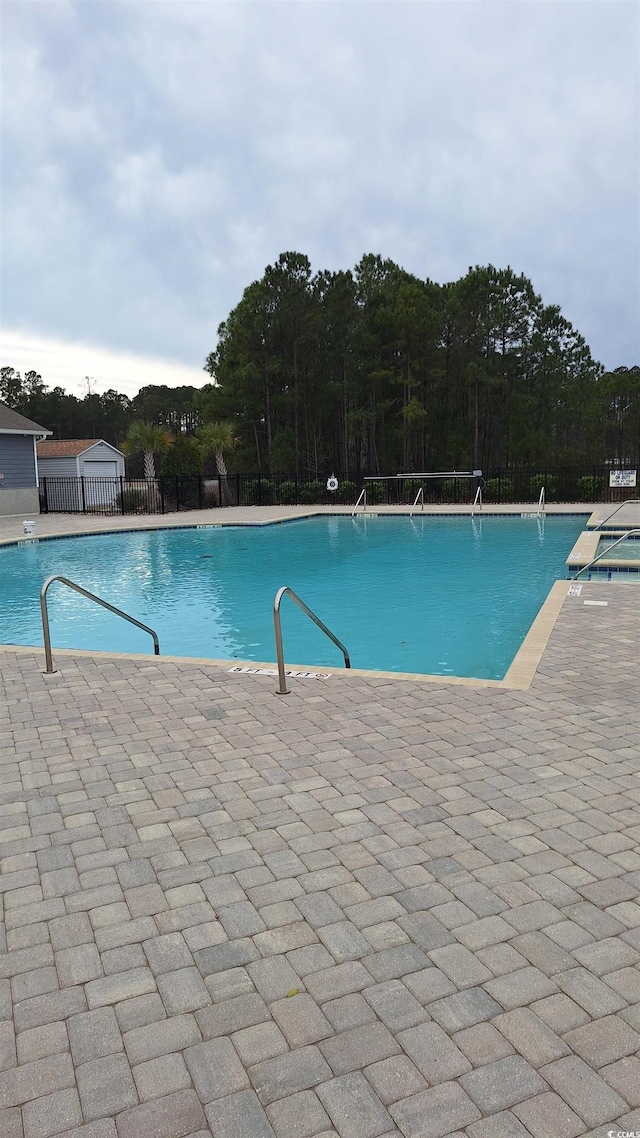 pool featuring a patio and fence