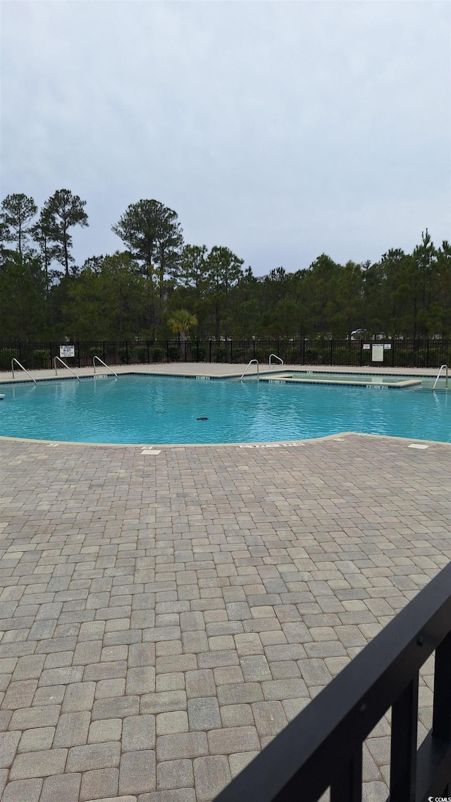 pool with a patio and fence