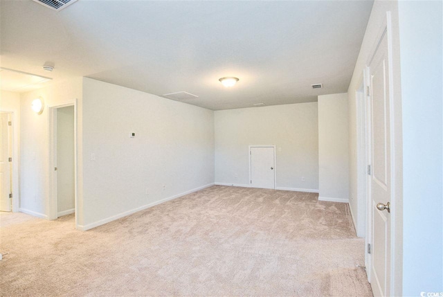 empty room featuring visible vents, baseboards, and light colored carpet