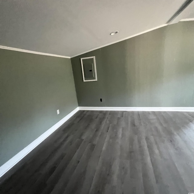 interior space featuring ornamental molding, electric panel, baseboards, dark wood-style flooring, and vaulted ceiling