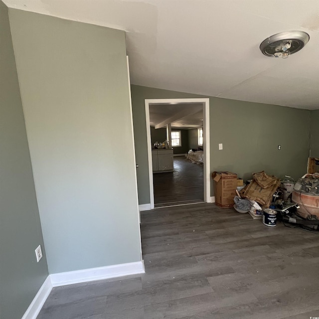 empty room with lofted ceiling, baseboards, and wood finished floors