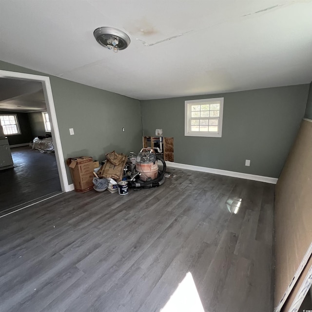 interior space featuring baseboards, multiple windows, and wood finished floors