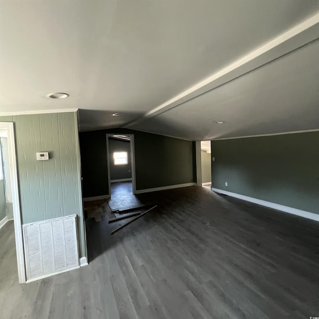 interior space with visible vents, baseboards, wood finished floors, and vaulted ceiling