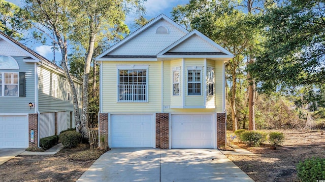 view of front of home with a garage, concrete driveway, and brick siding