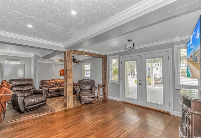 living area with ornamental molding, french doors, and wood finished floors