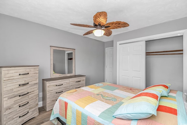 bedroom featuring light wood-type flooring, ceiling fan, and a closet