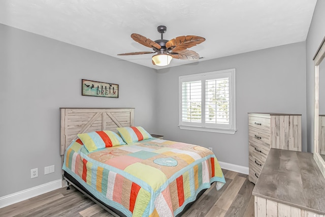 bedroom with ceiling fan, baseboards, and wood finished floors