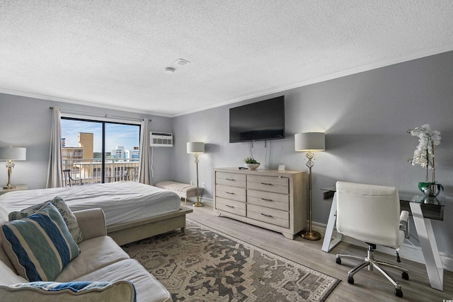 bedroom with access to exterior, ornamental molding, a wall mounted AC, and wood finished floors