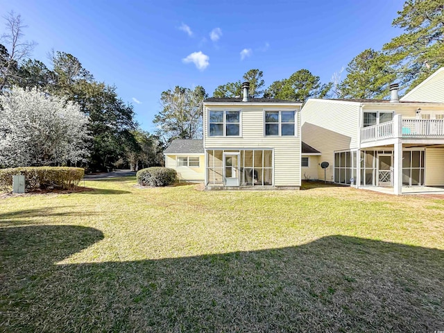 back of house featuring a yard and a sunroom