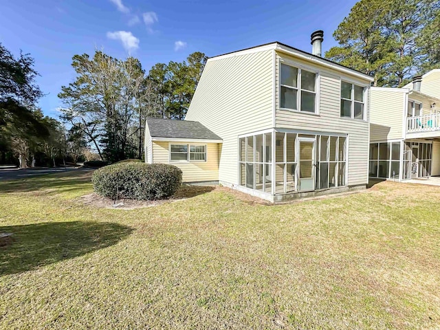 back of property featuring a lawn and a sunroom