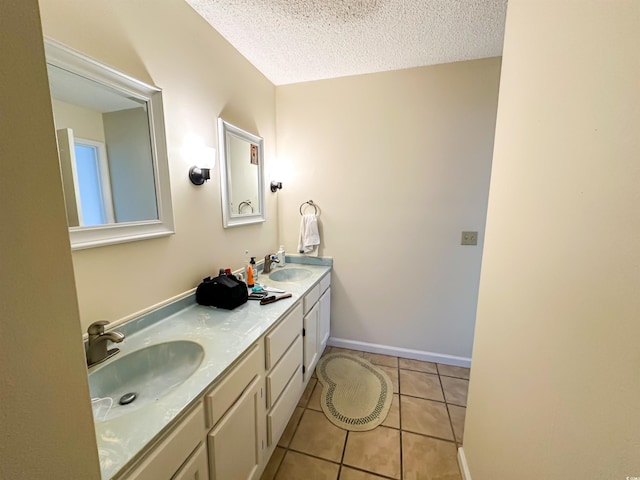 bathroom with tile patterned flooring, a textured ceiling, double vanity, and a sink