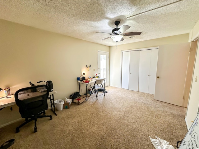 office area featuring a ceiling fan, carpet flooring, and a textured ceiling