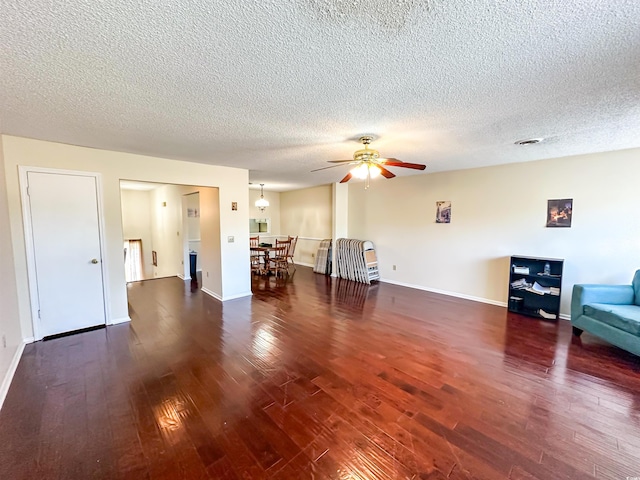 unfurnished living room featuring baseboards, visible vents, ceiling fan, hardwood / wood-style flooring, and a textured ceiling