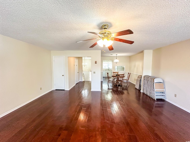 interior space with a ceiling fan, wood finished floors, baseboards, and a textured ceiling