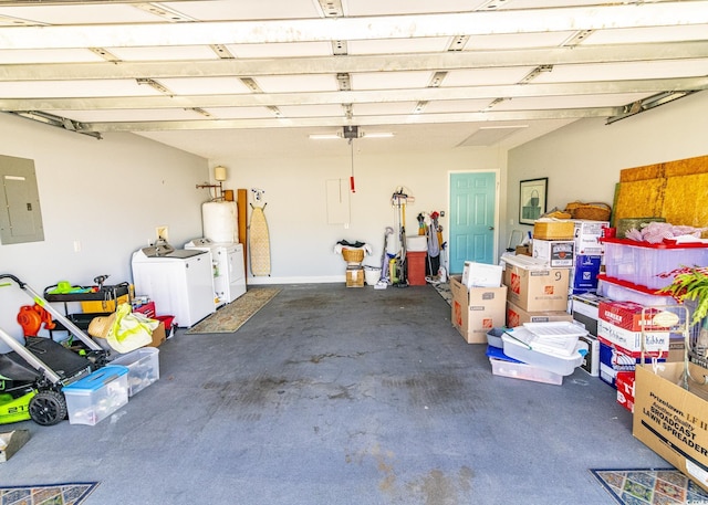 garage featuring water heater, washing machine and clothes dryer, and electric panel